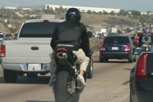 A motorcyclist Lane Sharing in CA where it is legal. Credit: Eric Schmuttenmaer (CC BY SA)