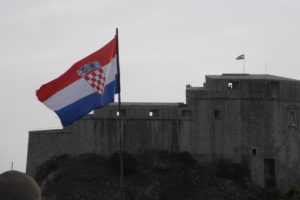 克罗地亚旗帜挥手在一个古老而非常坚实的边界帖子上。